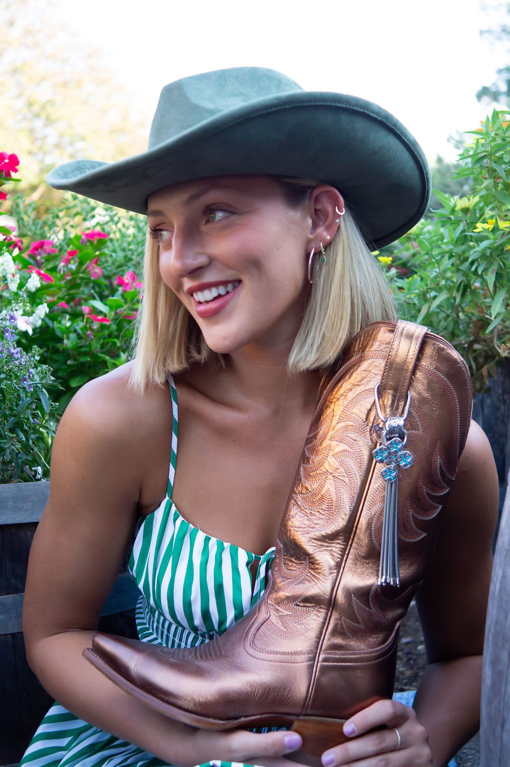 Woman in hat holding cowboy boot.