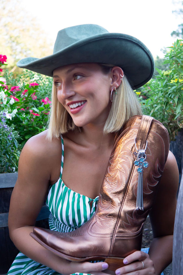 Woman in hat holding cowboy boot.