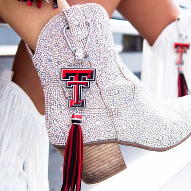Sparkly boots with red tassel and emblem.
