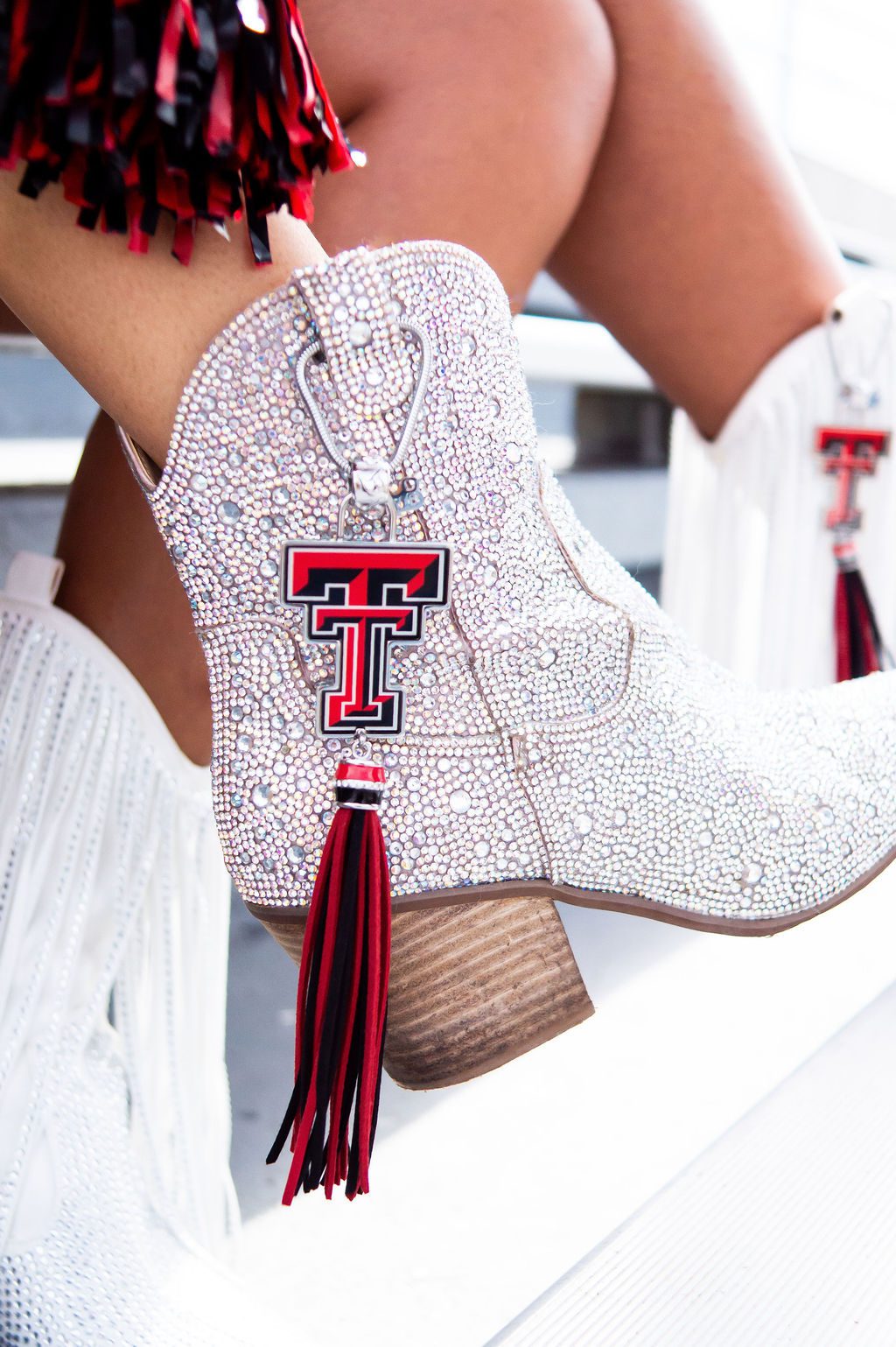 Sparkly boots with red tassel and emblem.