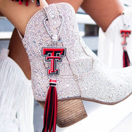 Sparkly boots with red tassel and emblem.