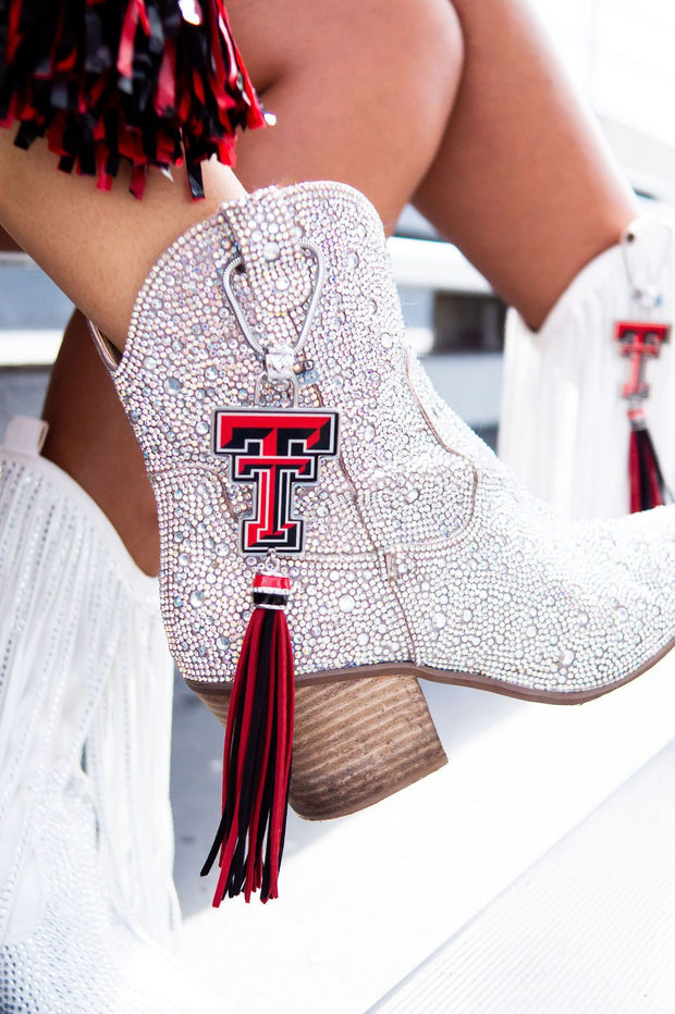 Sparkly boots with red tassel and emblem.
