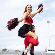 Cheerleaders performing on a football field.
