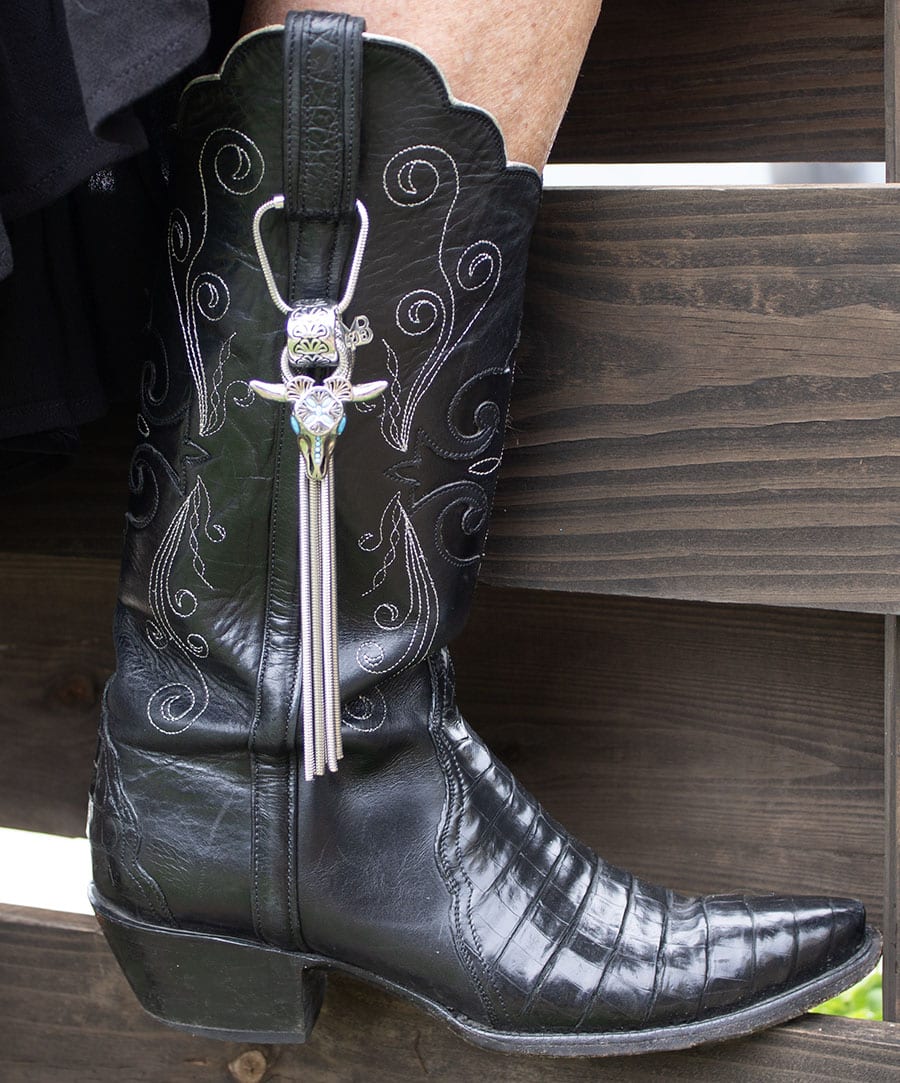 Black cowboy boot with the stainless steel Mizz Boot Bola Steer Skull Accessory. 