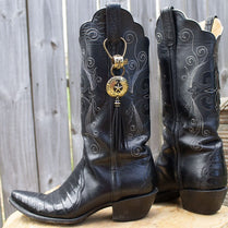 Pair of worn black leather cowboy boots with intricate stitching.