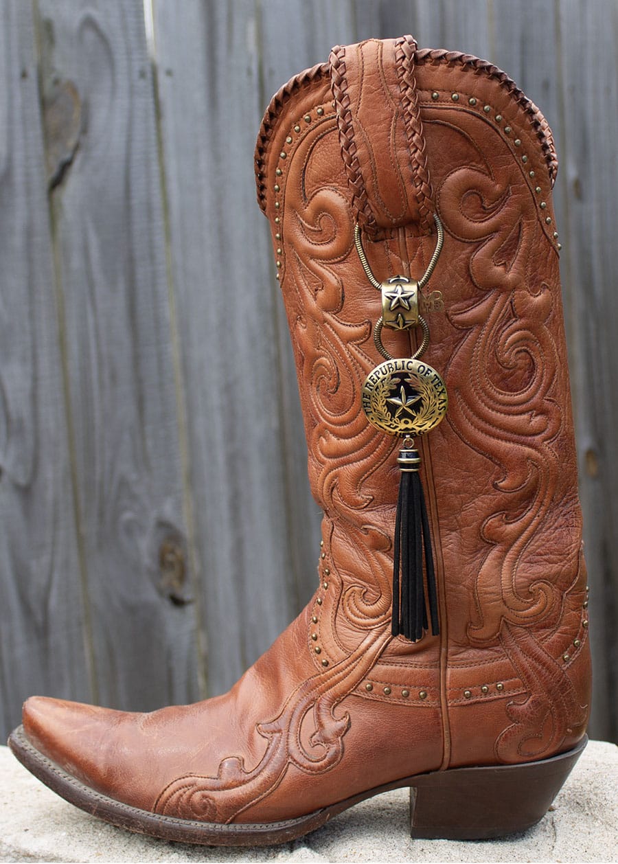 Close-up of an ornate orange cowboy boot with a decorative tassel.