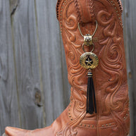 Close-up of an ornate orange cowboy boot with a decorative tassel.